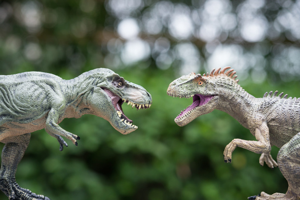 tyrannosaurus and allosaurus toy in front of trees - Zdjęcie, obraz