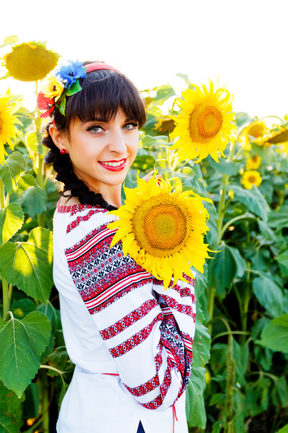 Krásná mladá dívka v tiskárny drží slunečnice na plán - Fotografie, Obrázek