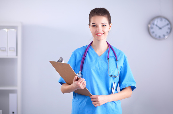 Woman doctor standing with folder at hospital - 写真・画像