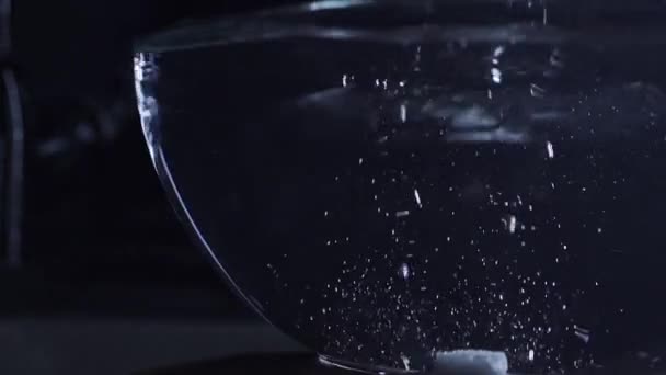 Tree sugar cubes fall into a glass cup with water, slow motion video - Footage, Video