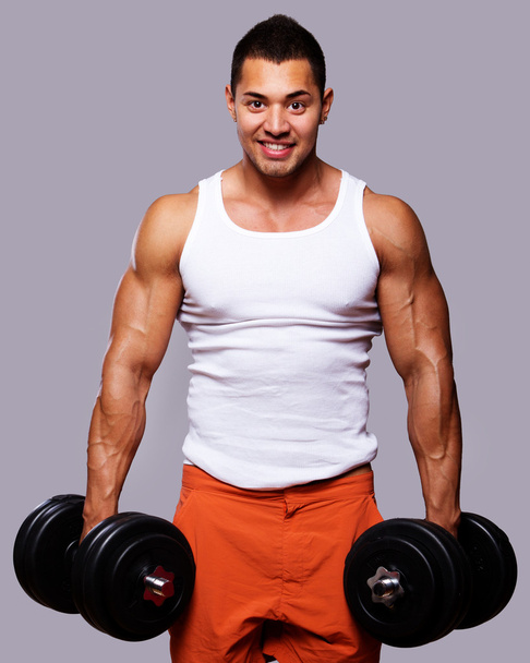 přizpůsobit svalnatý muž cvičení s činkami - Fotografie, Obrázek