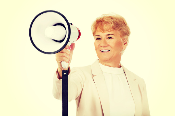 Senior smiling woman screaming through a megaphone - Foto, imagen