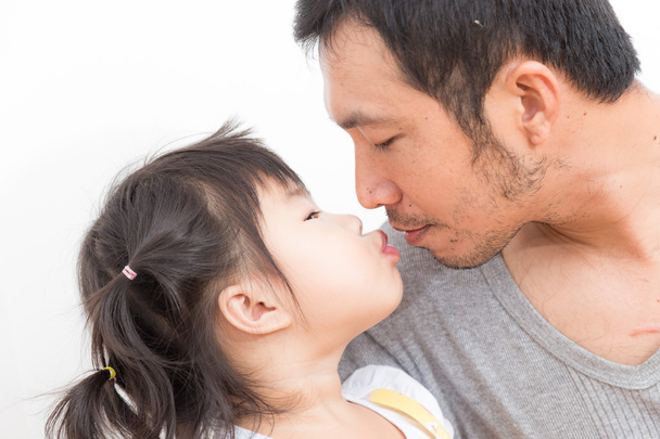 Азиатская девушка целует и обнимает своего отца на белом фоне
 - Фото, изображение