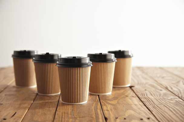 Five carton paper cups with black caps  - Foto, imagen