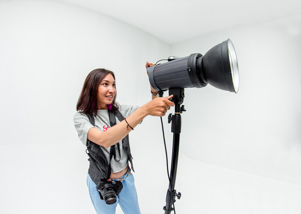 Γυναίκα φωτογράφος προσαρμόζει εξοπλισμός φλας, φωτογραφική μηχανή και softbox εγώ - Φωτογραφία, εικόνα