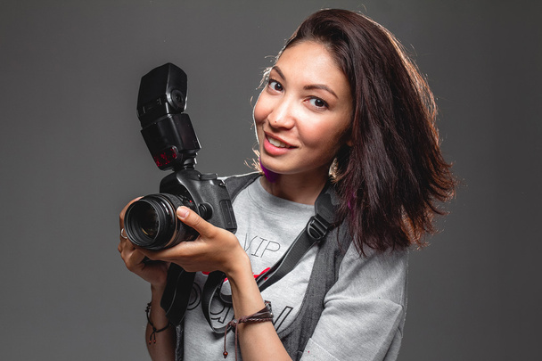 Mutlu genç kadın ile gri bir arka karşı modern dijital fotoğraf makinesi - Fotoğraf, Görsel