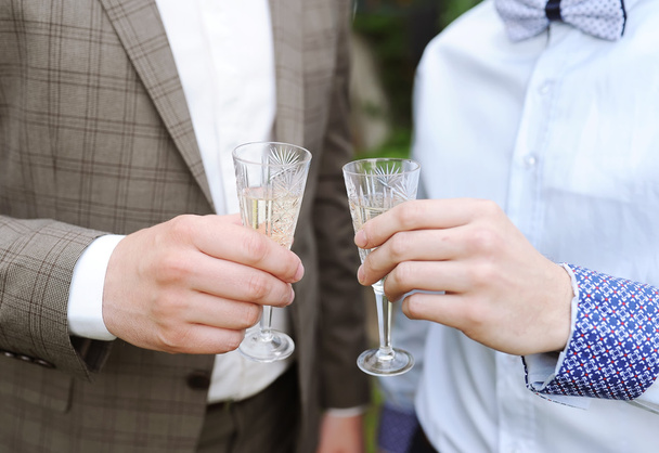The groom and his friend drink champagne from glasses. - Zdjęcie, obraz