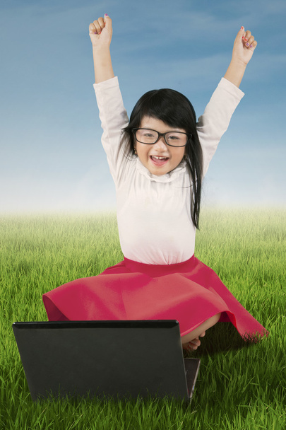 Радісна дитина з ноутбуком на траві
 - Фото, зображення