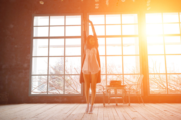 Attraente giovane donna che balla vicino a enormi meraviglie nel suo appartamento
 - Foto, immagini