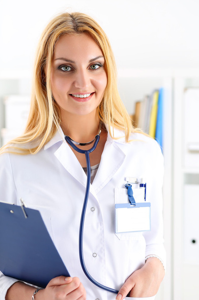 Красивая улыбающаяся женщина-врач держит планшет
 - Фото, изображение