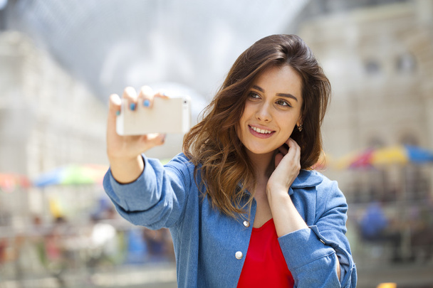 beautiful, smiling woman take a picture of herself with a smartp - Foto, Bild