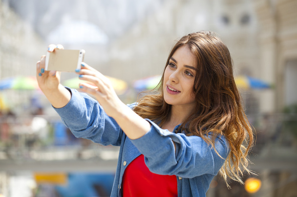 beautiful, smiling woman take a picture of herself with a smartp - Фото, изображение