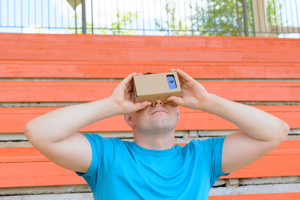 Young man looking into a virtual reality glasses - Photo, Image