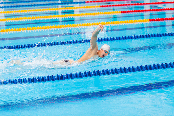 Man swimmer swimming crawl in blue water. - Fotó, kép