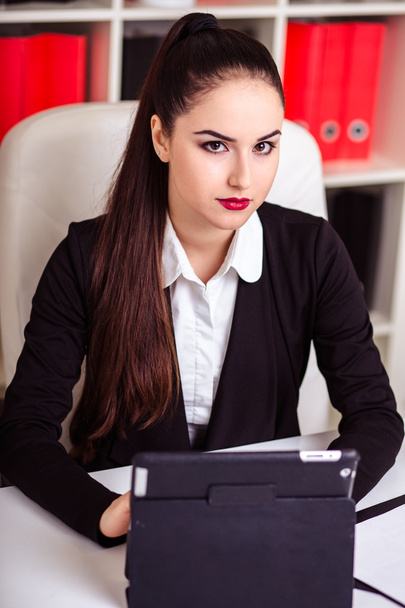 beautiful modern businesswoman in her office with a paper folder and tablet computer and mobile phone - Photo, Image
