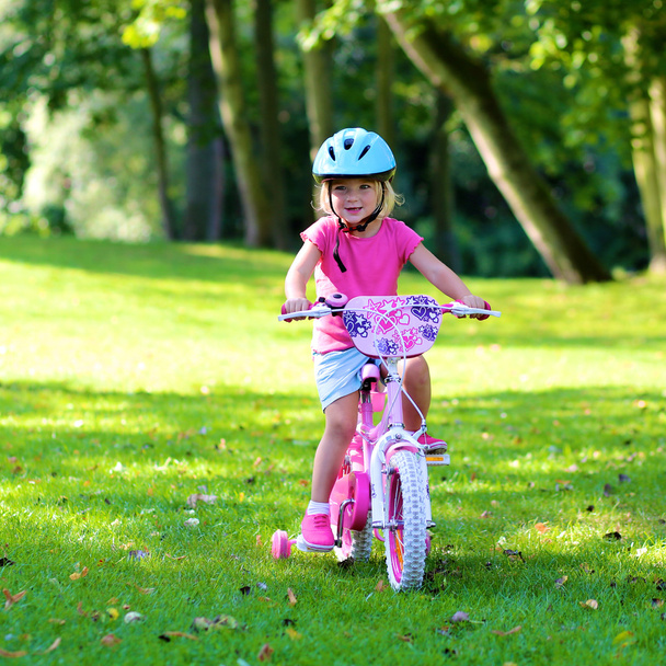 Toddler girl riding with her bike - Фото, изображение