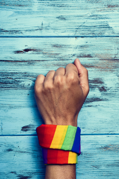 man with a rainbow-patterned kerchief in his wrist - Photo, Image