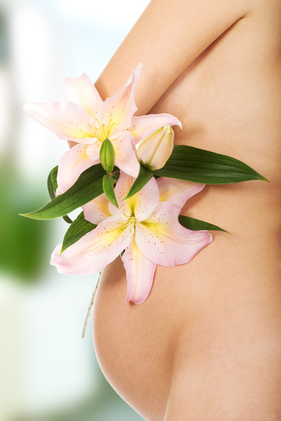 Pregnant woman holding a lily flower - Foto, Imagen