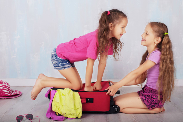 children play and laugh with a suitcase - Photo, Image