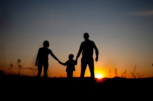 silhouet van familie op de outdoor in de schemering. Concept van vriendelijke familie. - Foto, afbeelding