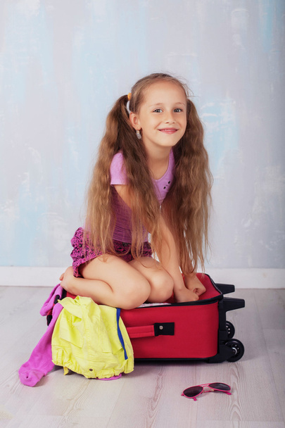 happy child with very long hair near a suitcase - Fotoğraf, Görsel