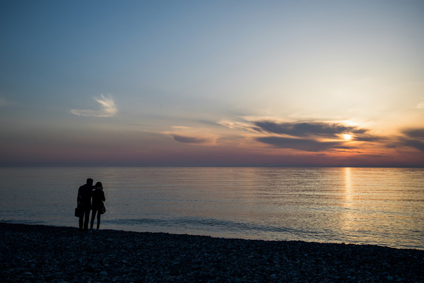 couple in love back light silhouette at lake sunset full length - Foto, Imagen