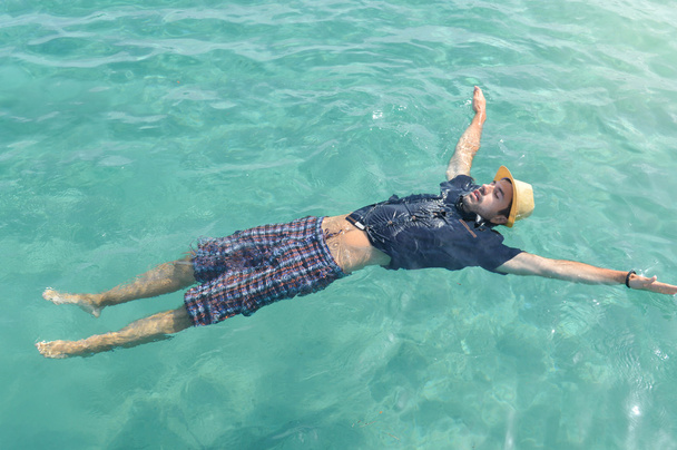 uomo galleggiante sull'acqua. Relax estivo
 - Foto, immagini