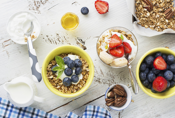 Healthy breakfast Fresh granola, muesli in bowl with milk and berries on a white background - Photo, image