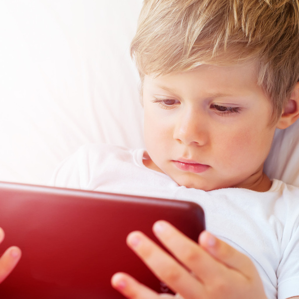 Child focused on screen tablet. Theme of modern technologies - Φωτογραφία, εικόνα