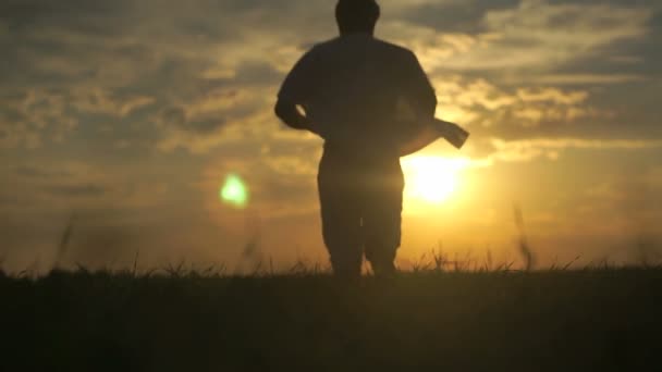 Siluetti mies juoksee kohti kaunista auringonlaskua
 - Materiaali, video