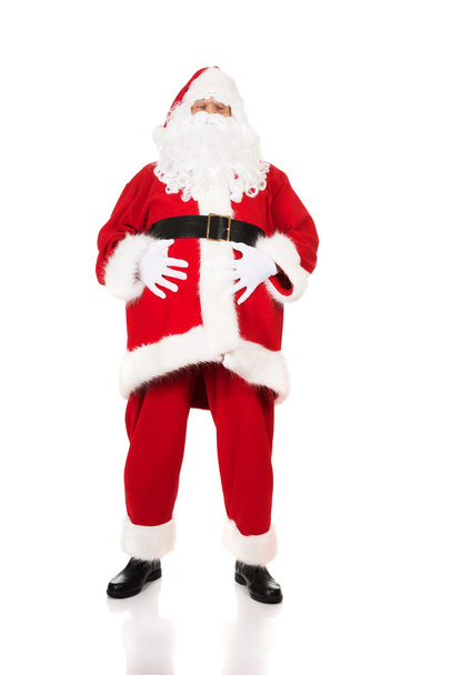 Szczęśliwy Święty Mikołaj trzyma swój tłusty brzuch - Zdjęcie, obraz