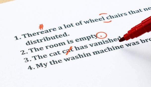 Engelse zinnen en corrigeren symbolen op witte vel - Foto, afbeelding