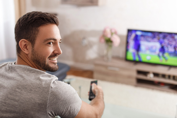 Excited man switch TV to soccer - Photo, Image