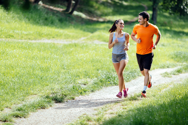 Beautiful couple jogging in nature - Фото, зображення