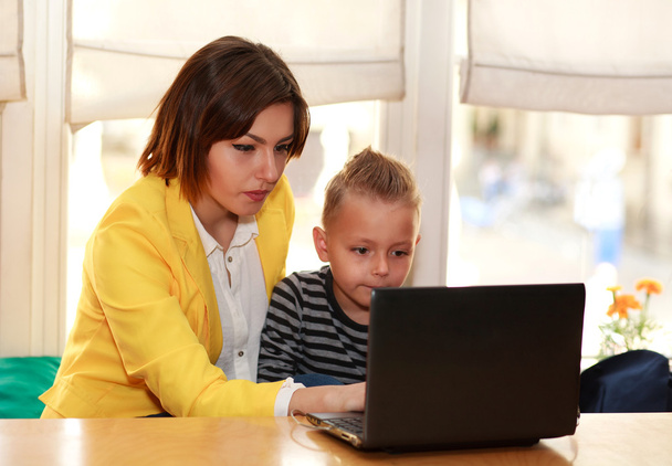 Mother and son at home doing lessons looking at laptop - Φωτογραφία, εικόνα