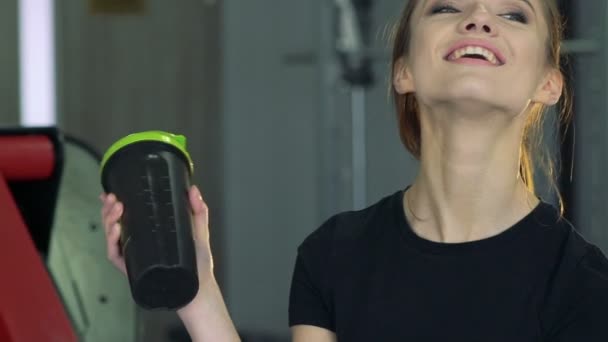 Beautiful girl with a shaker in the gym - Imágenes, Vídeo