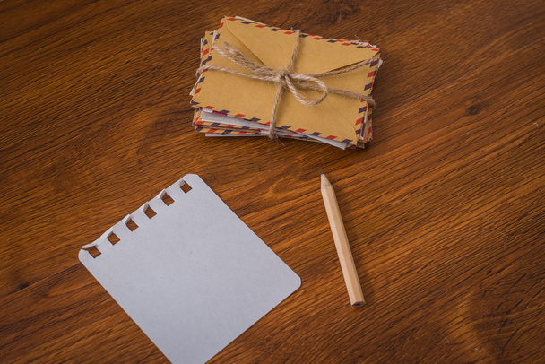 Bundle envelopes with pen and with paper wood table - 写真・画像