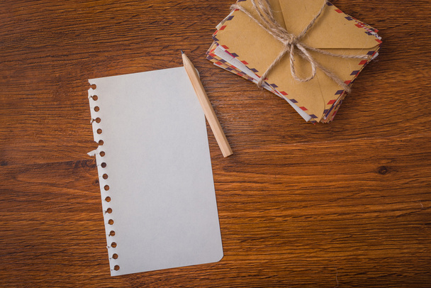 Пучкові конверти з ручкою і паперовим дерев'яним столом
 - Фото, зображення