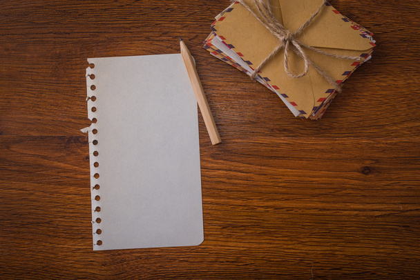 Sobres de paquete con bolígrafo y mesa de madera de papel
 - Foto, Imagen
