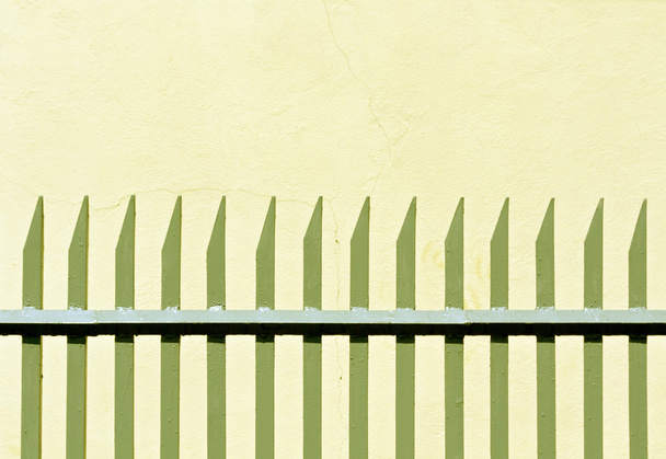 Gray metal fence and plaster wall.  - Fotoğraf, Görsel