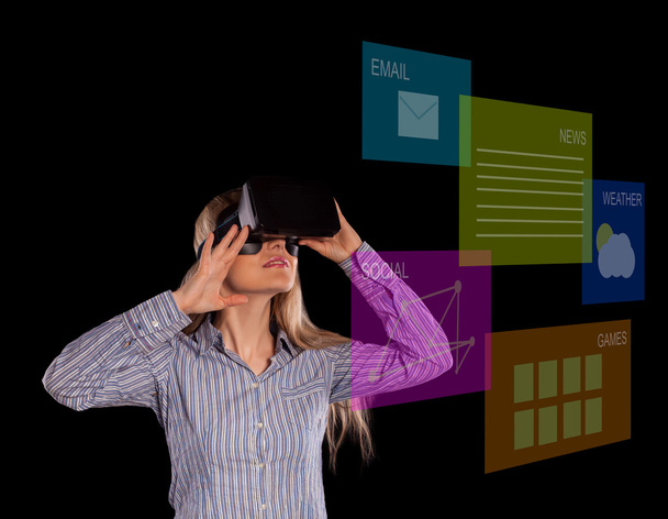 Intrigued woman in grey shirt wearing virtual reality 3D headset - Photo, Image