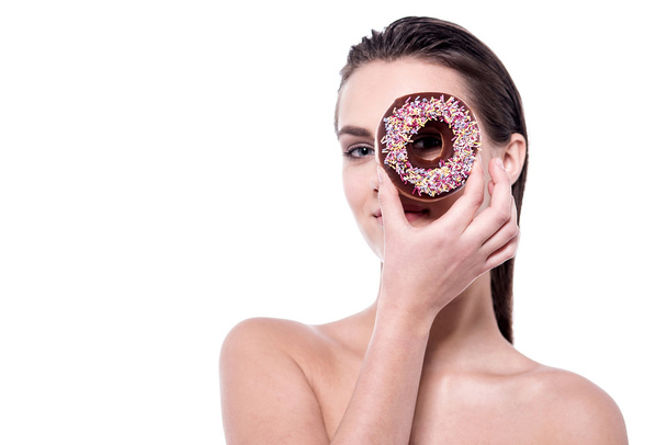 Topless woman focusing through the donut - Foto, afbeelding