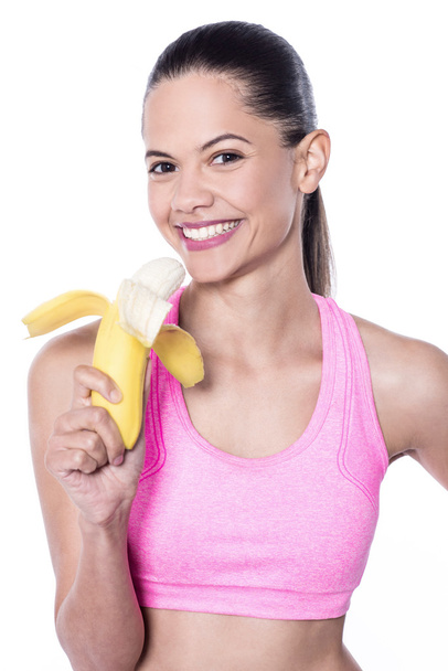 Slim fit woman eating banana - Fotoğraf, Görsel