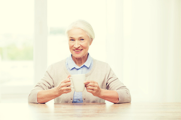 happy senior woman with cup of tea or coffee - Photo, Image
