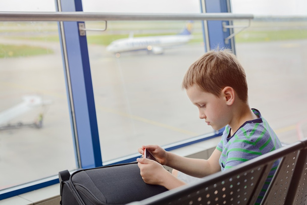 Bored 7 years old boy child waiting for his plane - Fotoğraf, Görsel