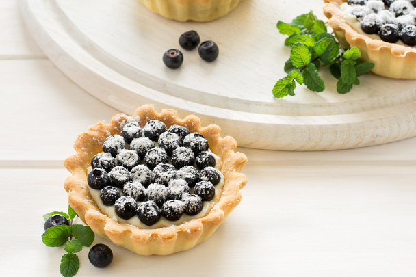Close up of tartlets with fresh blueberries, decorated mint leaves - Фото, зображення
