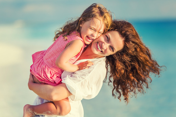 Happy mother and daughter on the beach - Foto, imagen