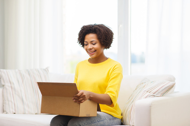 happy african young woman with parcel box at home - Foto, imagen