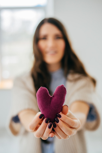 Girl  holds handmade toy heart - Foto, imagen