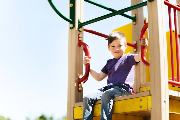 fröhlicher kleiner Junge klettert auf Kinderspielplatz - Foto, Bild